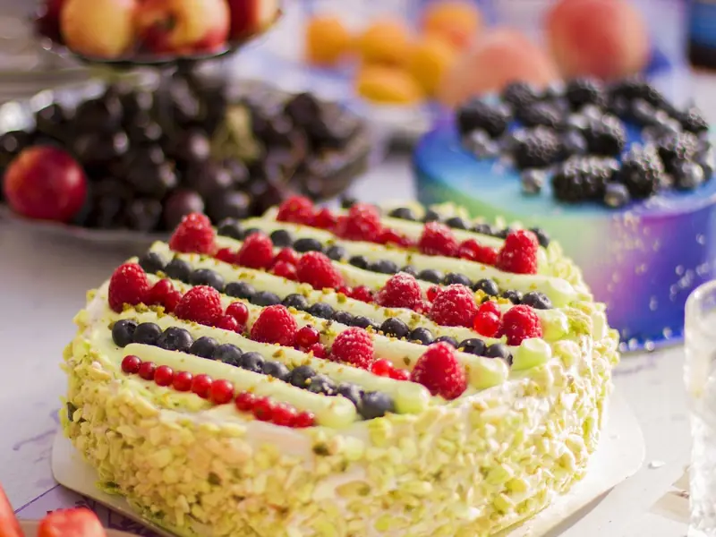 A fresh cream cake decorated with raspberries and blueberries