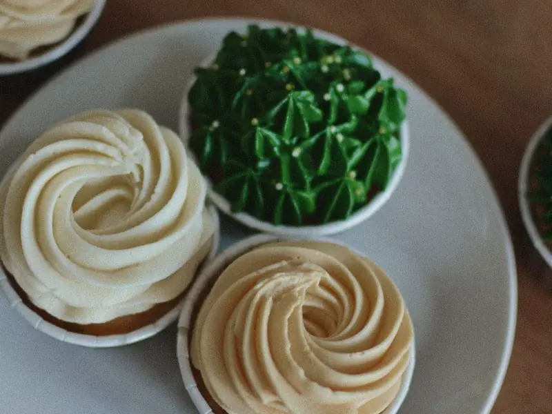 Tartlets topped with swirls of cream on a plate